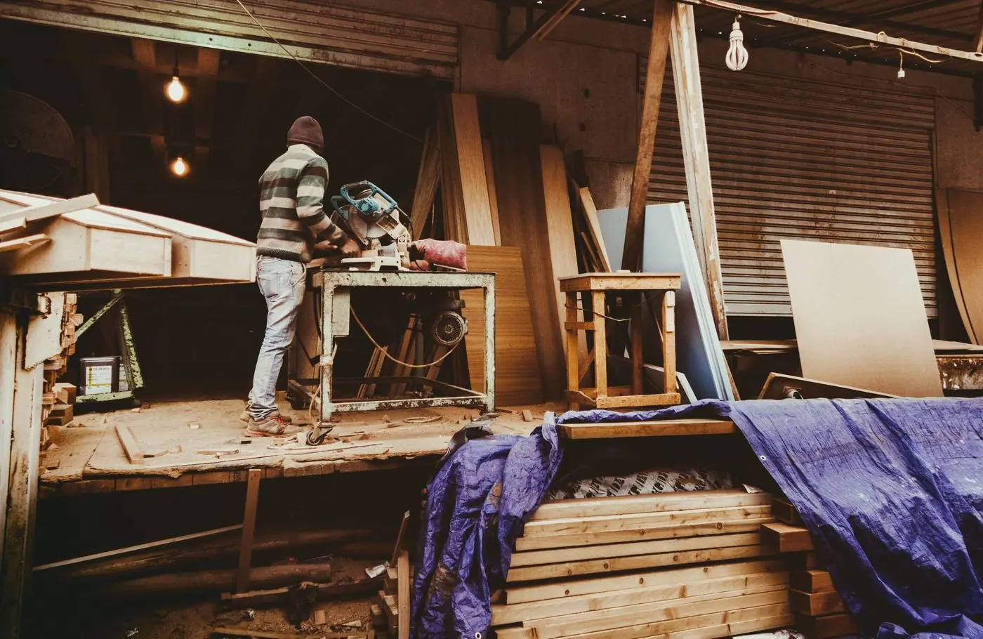 Werkplaats met houtbewerker en houten balken